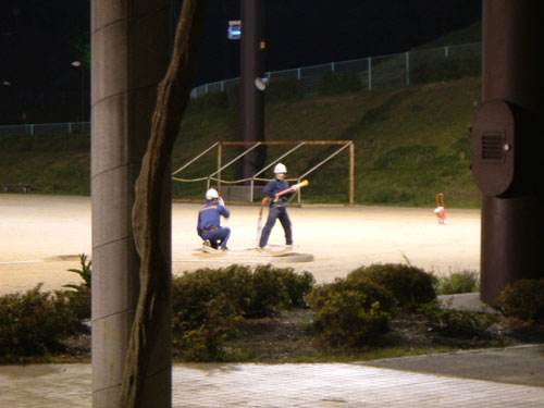 隣りのグラウンドで練習をする消防団