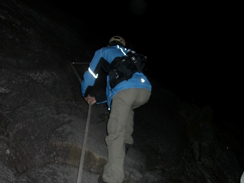 キナバル山頂へ　ロープを掴んで岩場を登る人