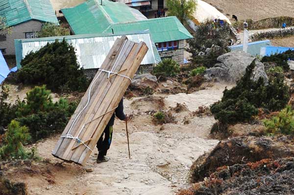 ネパール　急登で材木をかつぐ人