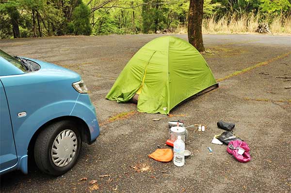 駐車場にテントを張る登山者